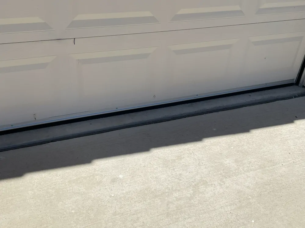 Close-up of a garage door sweep attached along the bottom of a garage door.